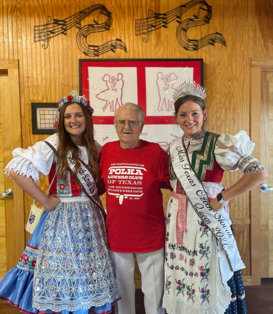 A man and two women in traditional costumes posing for a picture.