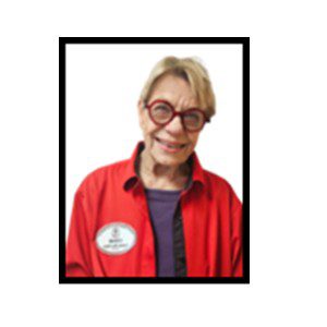 Smiling woman wearing glasses and teal shirt.