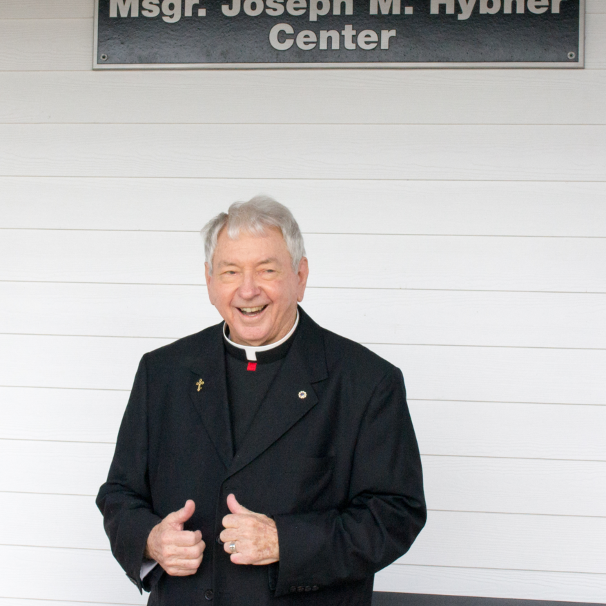 A man in black jacket giving thumbs up.