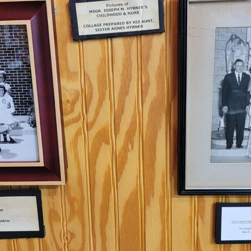 A wall with several old photos of people hanging on it.