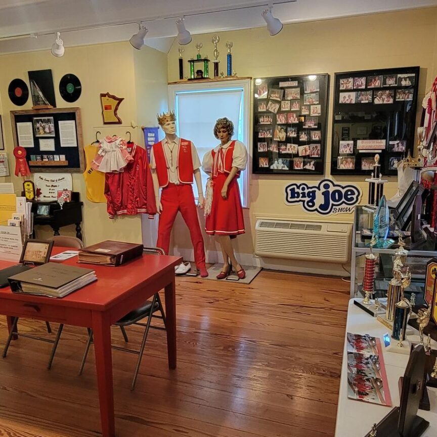 A room with two mannequins in red outfits.